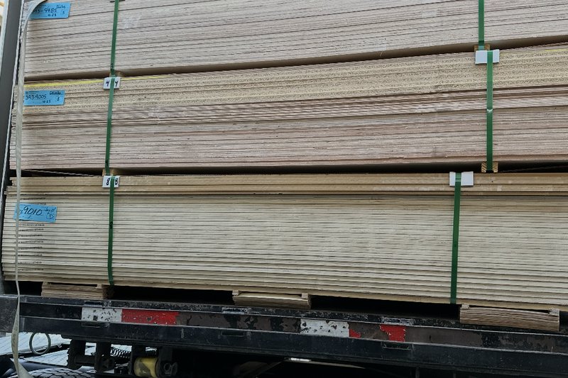 Panel stock loaded and strapped onto a flatbed truck for delivery