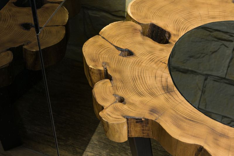 Live edge wood slab table detail showing natural bark edge