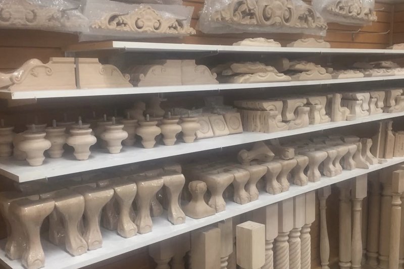 Shelves of unfinished wood corbels, appliques, and turned legs at a millwork showroom