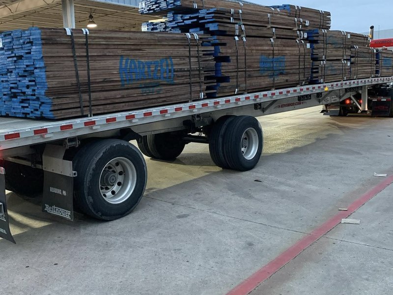 Flatbed truck loaded with bundled hardwood lumber ready for delivery